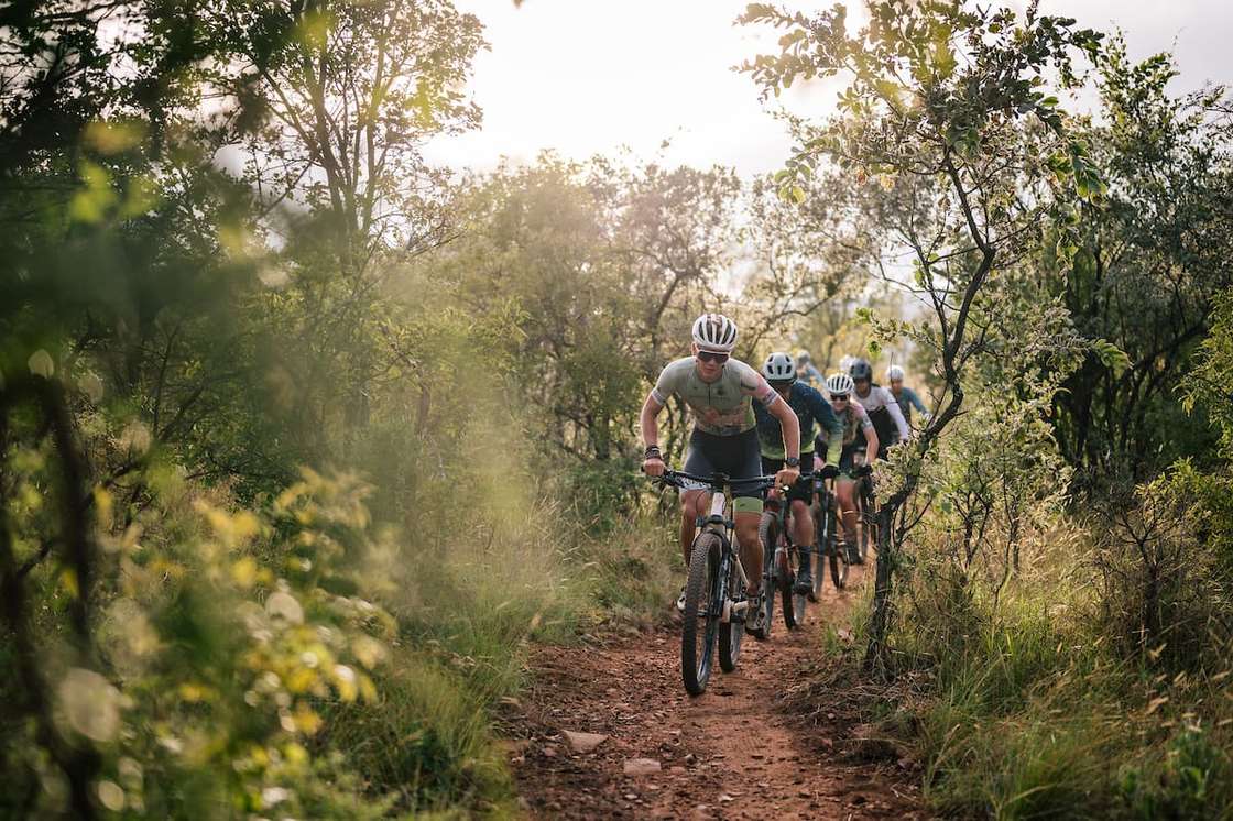A group of riders on singletrack through the bushveld